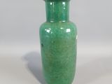 a green vase that is sitting on a table
