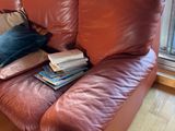 a man sitting on a couch reading a book