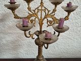 a gold colored candelab with pink candles on it