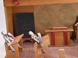 a wooden model of a classroom with a chalkboard on the wall