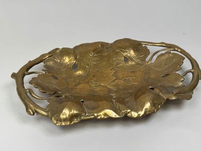 une image représentant une plaque en laiton ornée de feuilles