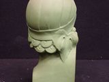 a green statue of a man with a hat on