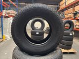 tires are stacked on pallets in a warehouse with pallets in the background