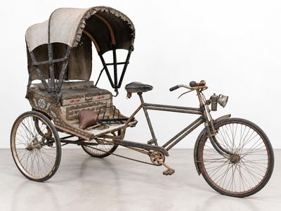 an old fashioned rickshaw with a canopy on the back of it