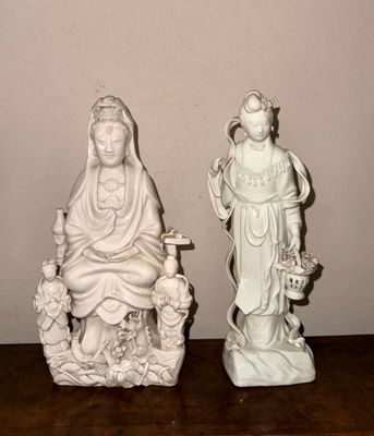 deux statues représentant une femme et un homme assis sur un banc
