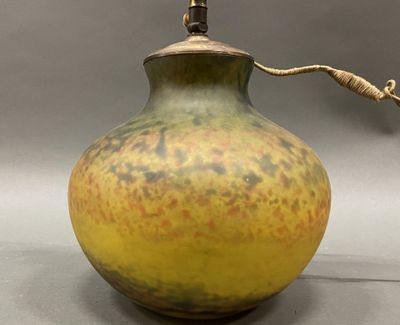 a yellow and brown vase with a rope on top of it
