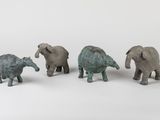 three small elephant figurines are standing next to each other on a white surface