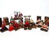 de nombreuses figurines représentant des personnes assises sur une surface blanche