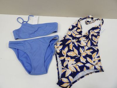 two swimsuits on a table with a tag on it