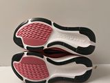 pair of pink and black shoes on a white surface with a white background