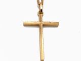 pendentif en forme de croix en or, suspendu à une chaîne en or, sur fond blanc