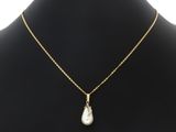un collier en or avec un pendentif en perle autour du cou d'un mannequin