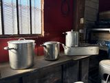 Plusieurs casseroles et poêles sont posées sur une étagère dans une cuisine