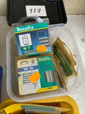 a plastic container filled with different types of staples and staples