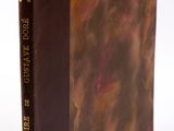 un vieux livre à la couverture brune posé sur une surface blanche