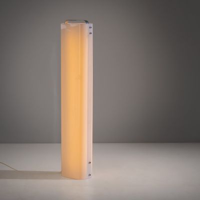 une lampe blanche posée sur une table près d'un mur