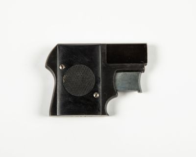 a close up of a black gun on a white surface
