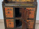 a small cabinet with a door open on a tiled floor