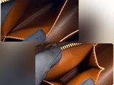 the inside of a brown and yellow purse with a zipper