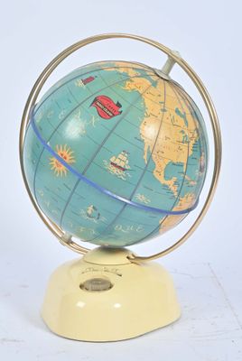un globe bleu et jaune posé sur un socle, sur une surface blanche