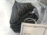 a pile of black yarn in a plastic bag