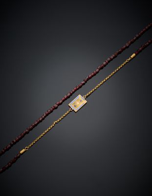 un collier composé de perles dorées et rouges, muni d'un fermoir plaqué or