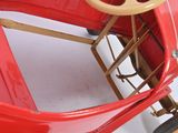 a red toy car that is sitting on the floor
