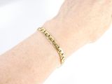 someone is wearing a gold bracelet with a star design on it