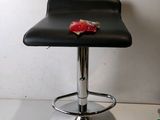 a black bar stool with a red piece of food on it