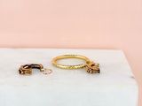a pair of gold hoop earrings on a marble block