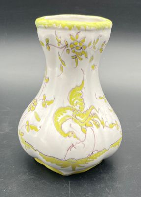 a yellow and white vase sitting on a table
