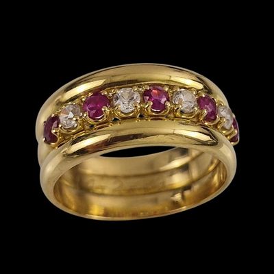 gros plan d'une bague en or avec des pierres roses et blanches