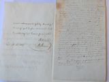 two old papers with handwriting on them sitting on top of a table