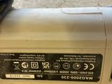 a close up of a corded sander on a carpeted floor