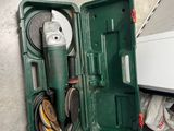 a green box with tools inside of it on the floor