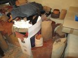 une pile de chaussures et de sacs posés sur le sol