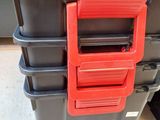 a stack of black and red storage containers on the floor
