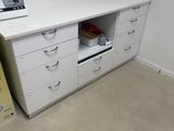 un bureau blanc avec des tiroirs, sur lequel est posé un ordinateur portable