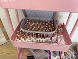 a pink cart filled with lots of makeup and nail polish