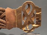 a gold belt with a knot on it on a table