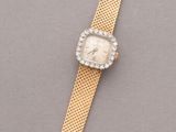 an image of a gold watch with a white face and a gold band