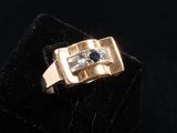 a close up of a gold ring with a blue stone