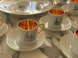 many cups and saucers sitting on a marble table