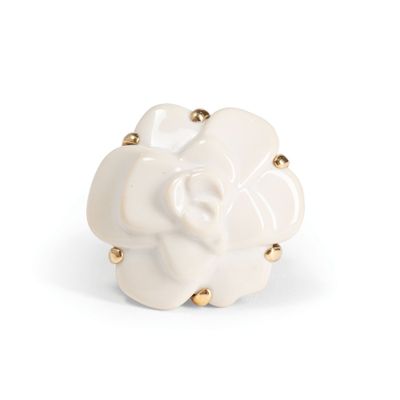 white ceramic flower with gold studs on a white background