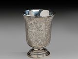 an antique silver cup with a floral design on the rim