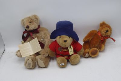 trois ours en peluche assis les uns à côté des autres sur une surface blanche