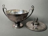 a silver bowl and a silver plate on a table