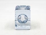 un glaçon percé d'un trou posé sur une surface blanche