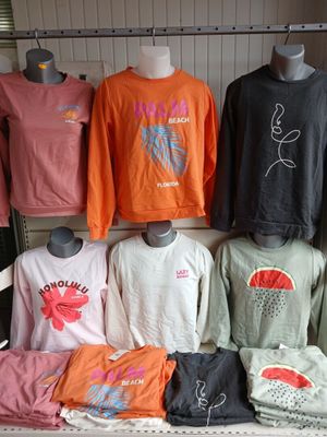 many different colored shirts on display in a store