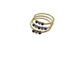 a close up of a gold ring with black stones on it
